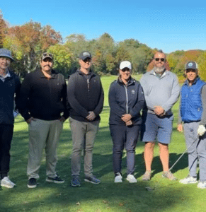 six adults stand outside on the Fresh Pond Golf Course